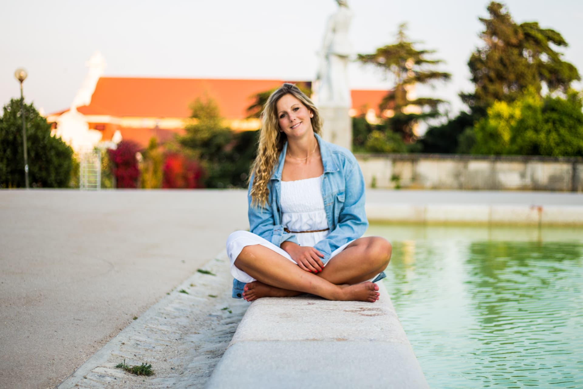 Mel sitting by a fountain at golden hour